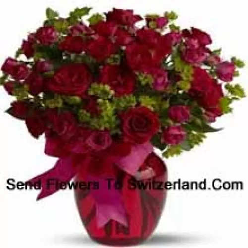 26朵红色和25朵粉色玫瑰，配有一些蕨类植物，放在玻璃花瓶中